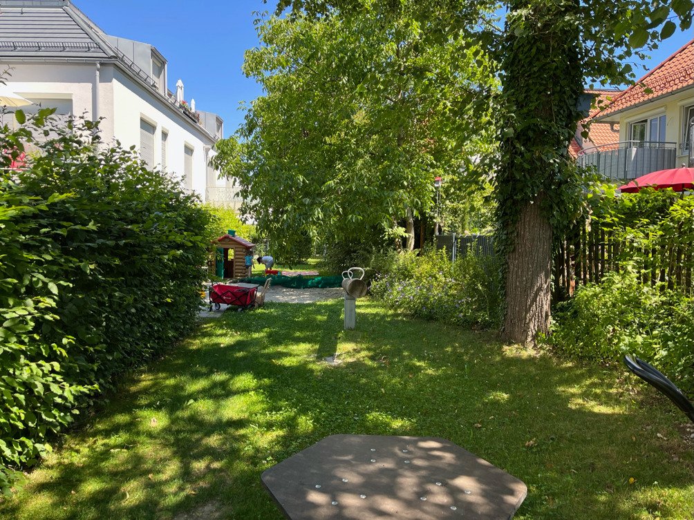 Schattiger Spielplatz mit altem Baumbestand in der Wohnanlage